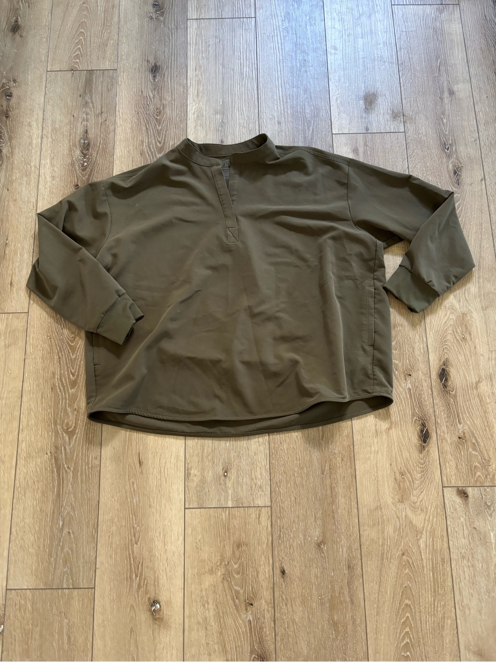 FIGS Rafaela Oversized Longsleeve Scrub Top in olive green.